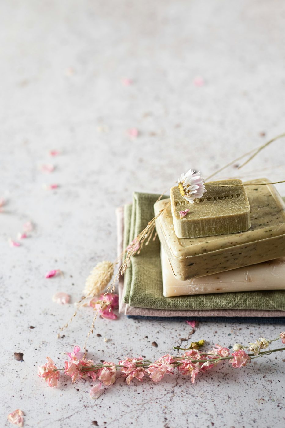 Savons artisanaux posés sur un linge avec des fleurs séchées